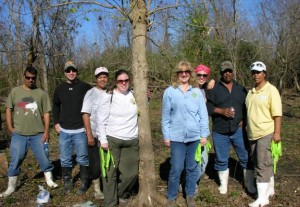 After a morning of clearing the scout camping area along Woodlands Trail,  Rosina Philippe (far right) America's Wetland Conservation Corps and volunteers prepare to tag the trees they planted that were donated by the Chevron Tree Farm.